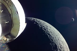 Луна, тонкий месяц Земли, и «селфи» космического корабля NASA Orion 5 декабря 2022 года. Orion совершал облет Луны в ходе первого испытательного беспилотного запуска по новой американской лунной программе «Артемида» (Artemis). В отличие от корабля Apollo, Orion оснащается четырьмя солнечными батареями в качестве источника электропитания. Солнечные батареи разворачиваются крестообразно в стороны от корабля и на законцовке каждой батареи размещается фотовидеокамера, которая позволяет снимать в одном кадре и сам корабль, и окрестные космические пейзажи. Электроника камеры позаимствована из обычной серийной экшн-камеры GoPro. Через шесть дней после облета космический корабль успешно приводнился в воды Тихого океана. Следующий подобный полет планируется в 2024 году с экипажем из четырех человек на борту, и эта экспедиция должна стать самым продолжительным полетом людей в межпланетном пространстве (но посадки на Луну пока не предполагается).