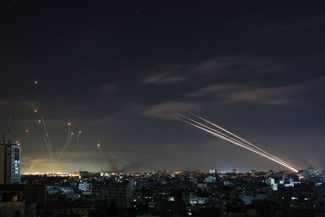 Израильская система противоракетной обороны «Железный купол» (слева) перехватывает ракеты, выпущенные боевиками ХАМАС (справа), ранее утро 16 мая 2021 года