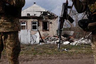 Военнослужащие ВСУ у дома, поврежденного в ходе вторжения РФ в Украину