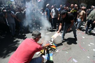 Anti-Pride demonstrators burning a rainbow flag in Tbilisi on July 5, 2021