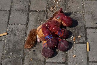 Детская игрушка с пятнами крови на земле у вокзала