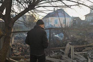 Житель Херсона во дворе своего дома, разрушенного во время обстрела