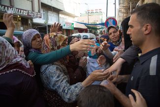Сирийские беженцы в очереди за талонами, которые можно обменять на хлеб. Турция, Газиантеп, 3 сентября 2014-го