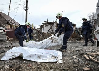 Rescuers carry the bodies of two people killed during the Russian raid on Zaporozhye, March 21, 2026.