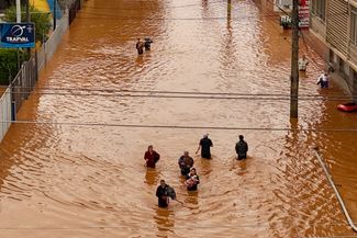 Жители Порту-Алегри идут по затопленной улице, 4 мая