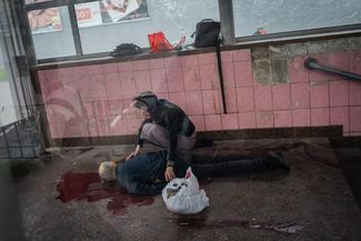 Женщина рядом с телом своего мужа, погибшего при обстреле города