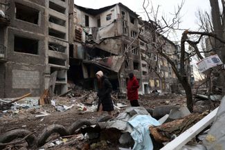 Жители Селидово рядом с жилым домом, в который попала российская ракета