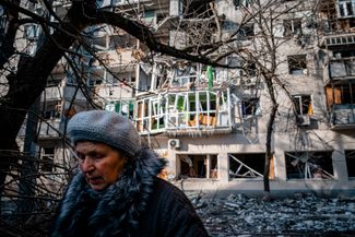Жительница Херсона возле разрушенной многоэтажки в западной части города