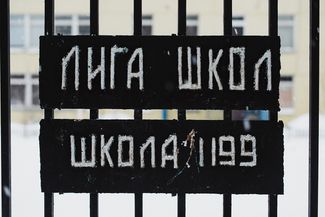The fence around the League of Schools building still features a plate with its name