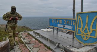 Украинский военный возле знака с названием острова Змеиный