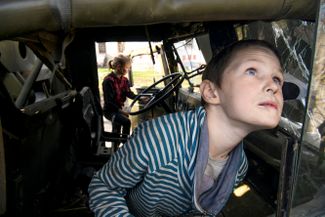 Мальчик Фадей из села Колычовка играет в разбитом военном грузовике российской армии
