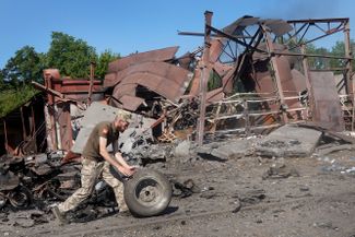 Служащий ВСУ осматривает помещение склада, уничтоженное во время обстрела и последующего пожара в Дружковке