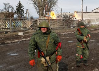 Бойцы пророссийских подразделений патрулируют улицы Волновахи. За их спинами горят перебитые газовые трубы