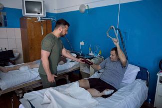 Президент Украины Владимир Зеленский вручает награду раненому бойцу ВСУ в госпитале