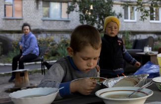 Шестилетний житель Изюма обедает во дворе многоквартирного дома в Изюме