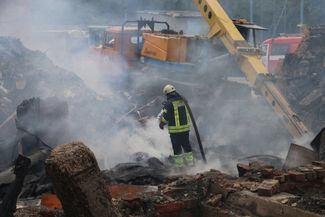 Пожарные работают на месте разрушенного авиаударами здания в Харькове