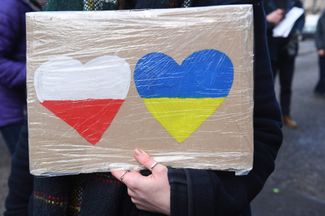 Протестующий держит плакат у консульства России в Эдинбурге. 25 февраля 2022 года