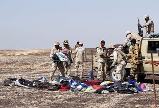 Египетские военнослужащие собирают личные вещи пассажиров российского самолета