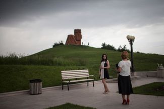 Свадебная фотография на фоне монумента «Мы — наши горы» у въезда в Степанакерт