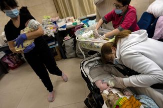 Кормление новорожденного в подвале киевского центра суррогатного материнства. Из-за войны родители не могут забрать из центра 19 детей