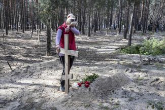Жительница Изюма у могилы своего мужа, погибшего в марте во время обстрела города
