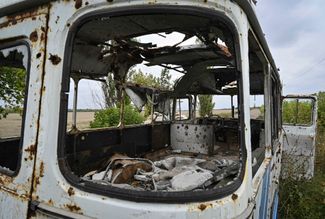 Разбитый автобус на обочине дороги недалеко от недавно освобожденного поселка Высокополье
