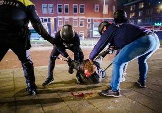 Задержание мужчины во время столкновений протестующих и полицейских в Роттердаме, 25 января 2021 года