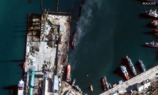 Спутниковый снимок компании Maxar Technologies, на котором показаны последствия атаки на российский десантный корабль в порту Феодосии. 26 декабря 2023 года