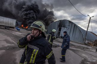 Пожарные пытаются потушить огонь на попавшем под обстрел складе с химическими веществами. Бровары, Киевская область