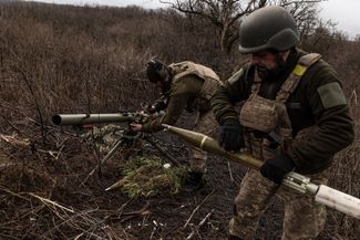 Украинские военные готовят выстрелы для безоткатного орудия на передовой рядом с Бахмутом