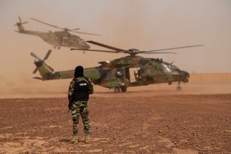 Военный французской группы оперативного вмешательства Национальной жандармерии рядом с вертолетом NH90 Caiman на военной базе Уаллам. 15 июля 2022 года