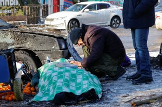 Муж женщины, погибшей в результате обстрела рынка «Меркурий», рядом с ее телом