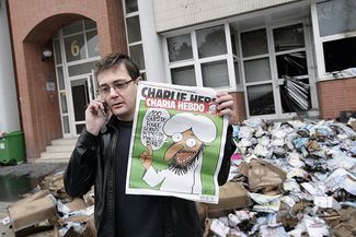 Главный редактор Charlie Hebdo Стефан Шарбонье рядом с выгоревшим зданием редакции, 2 ноября 2011-го