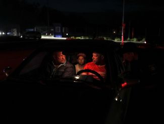 Беженцы из Мариуполя ожидают в машине по прибытии в центр для внутренних переселенцев. Мариуполь оккупирован российскими войсками и почти полностью разрушен