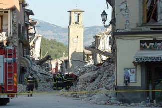 Пожарные на фоне разрушенной в августе церкви Святого Агостино в Аматриче