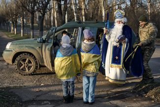 Военнослужащий бригады «Эдельвейс» в костюме святого Николая раздает подарки детям в Дружковке
