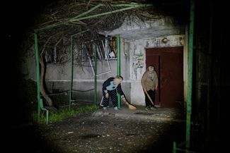 Жители Славянска прибирают территорию вокруг своего дома после ракетного удара