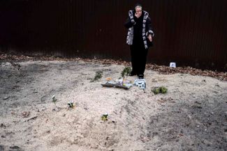 Жительница Бучи у могилы сына, похороненного в саду ее дома