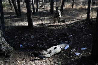 Украинский солдат рядом с телом российского десантника. Ирпень