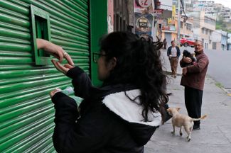 Магазин в Кито на фоне всплеска насилия продает товары через небольшое окно. 9 января 2024 года