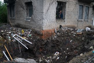 59-летний Олег Семенюк смотрит из окна на воронку, которая образовалась в результате взрыва снаряда. При обстреле пострадала квартира мужчины. «Я железнодорожник, и мы сделаны из железа», — заявил он журналистам.