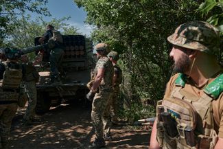 Украинские солдаты загружают ракеты в реактивную систему залпового огня «Град»