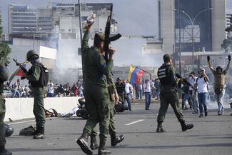 Members of the Bolivarian National Guard who joined Venezuelan opposition leader and self-proclaimed acting president Juan Guaido gesture after repelling forces loyal to President Nicolas Maduro, near LaCarlota military base in Caracas on April 30, 2019.