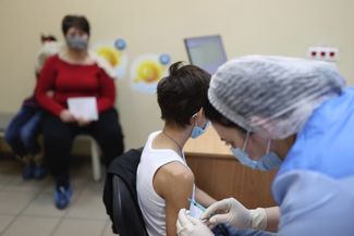 Подросток в сопровождении взрослого в пункте вакцинации в Краснодаре