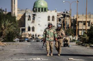 Бойцы «Бригады пустынных соколов», подразделения сирийской армии, в современной части Пальмиры. 27 марта 2016 года