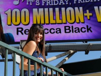 Ребекка Блэк на фоне билборда в честь 100 миллионов просмотров клипа «Friday». 15 апреля 2011 года