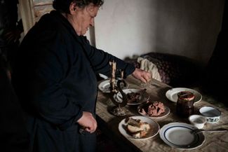 Жительница Бахмута Александра накрывает на стол. После обстрела в ее доме нет воды, электричества и газа