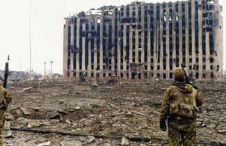 Солдат российских внутренних войск и руины президентского дворца. Грозный, январь 1995 года
