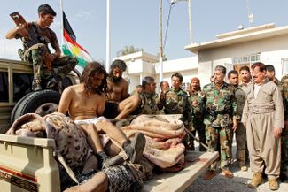 Курдские боевики с мужчиной, подозреваемым в сотрудничестве с «Исламским государством». Киркук, Ирак, 9 октября 2017 года