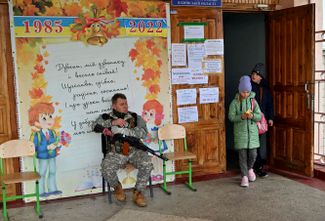 Боец украинской территориальной обороны охраняет вход в школу в городе Бородянка, недавно освобожденном от российской оккупации